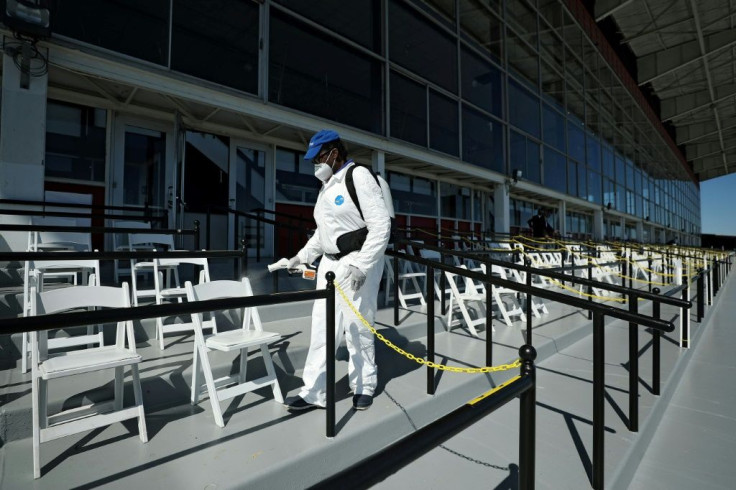 A worker disinfects seating for owners and trainers prior to the 145th Running of the Preakness Stakes at Pimlico Race Course in Baltimore, Maryland