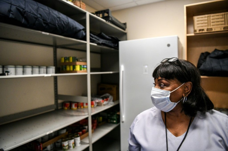 Annie Moore looks at the mostly empty shelves at a food pantry in Fayette, Mississippi