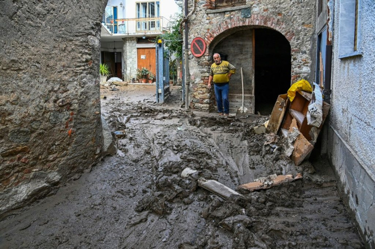 A man in Italy's Piedmont region surveys the damage outside his property after a mudslide brought on by the brutal weather