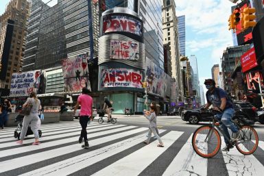 People cross the street near Time Square in New York City, which now faces potential re-imposition of virus restrictions in some neighborhoods