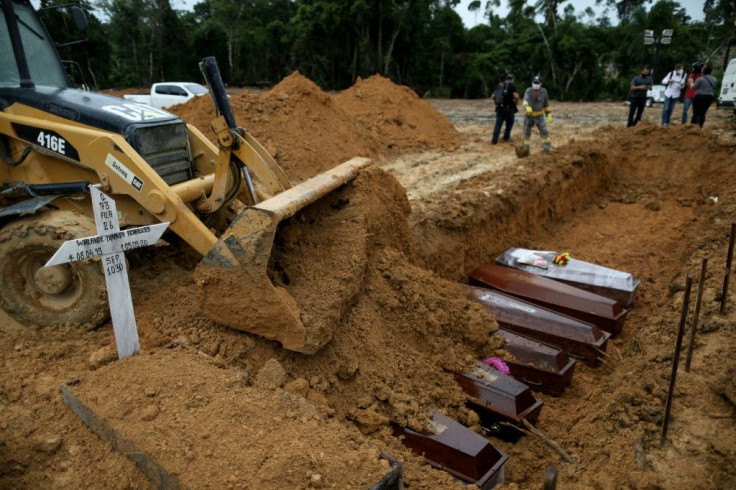 An excavator pushes earth over coffins at a mass grave at the Nossa Senhora cemetary in Manaus, Amazon state, Brazil in September 2020