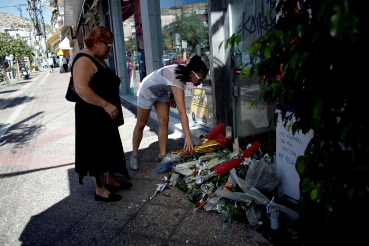 Women lay flowers on at the spot where rapper Pavlos Fyssas was stabbed to death in a suburb to the west of Athens in September 2013.
