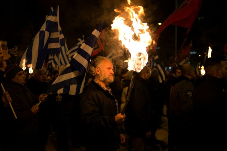 A supporter of Golden Dawn holds a torch, echoing Nazi and Ku Klux Klan imagery, at a gathering in central Athens in 2018.