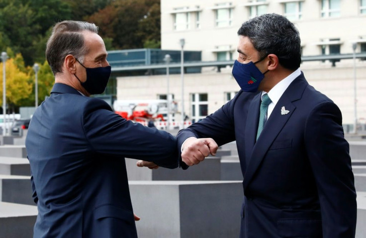 The Emirati (R) and Israeli foreign ministers bump elbows for their 'historic' first meeting at the Holocaust Memorial in Berlin