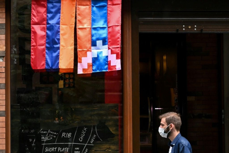Flags of Armenia and the Nagorno-Karabakh region adorn walls and shop fronts in Yerevan