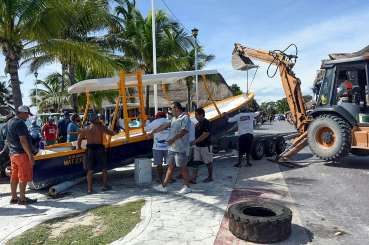 Fishermen in Puerto Morelos bring their boats ashore in preparation for the arrival of Hurricane Delta
