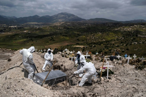 Cemetery workers wearing protective gear bury an unclaimed Covid-19 coronavirus victim in Tijuana, Baja California state, Mexico in April 2020 - the IMF has just warned it will take Mexico years to recover from the pandemic