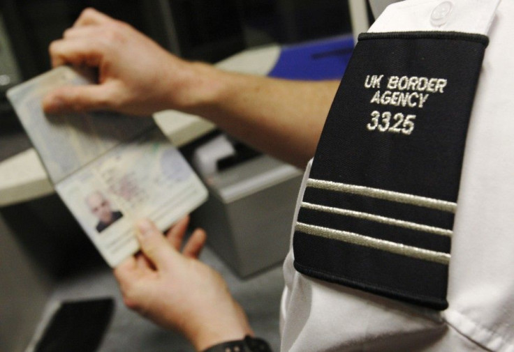 A UK Border Agency worker poses with a passport during a demonstration of the new facial recognition gates at Gatwick Airport near London