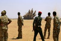 Sudanese soldiers watch as illegally held guns are destroyed in a controlled explosion, to launch a mass disarmament campaign in a country awash with firearms