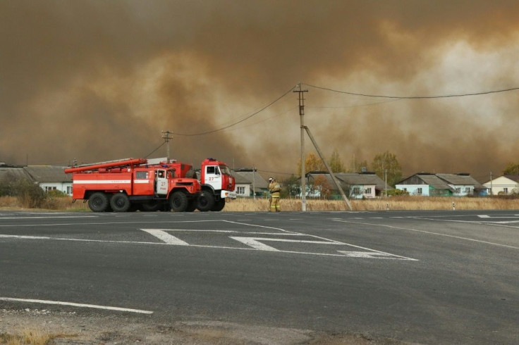 Smoke rises from a fire at a munitions depot as fire engines are seen on a road in the Ryazan region on October 7, 2020