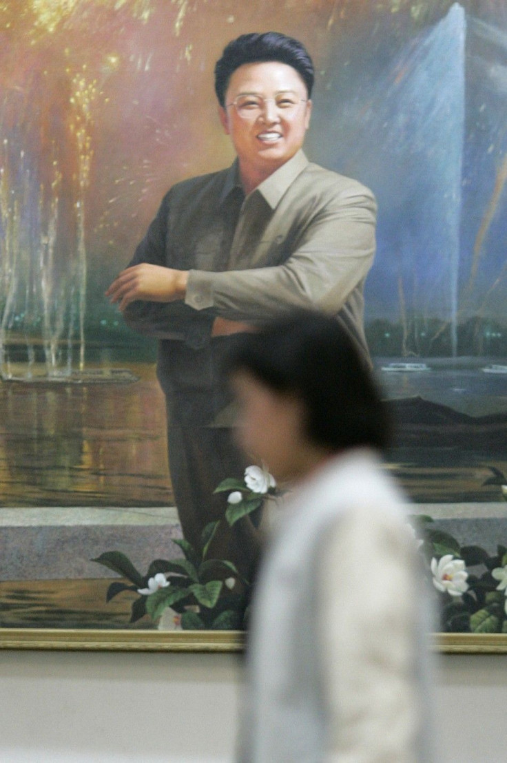 A woman walks past a portrait of North Korean leader Kim Jong-il at the lobby of the Grand People&#039;s Study House in the North Korean capital of Pyongyang