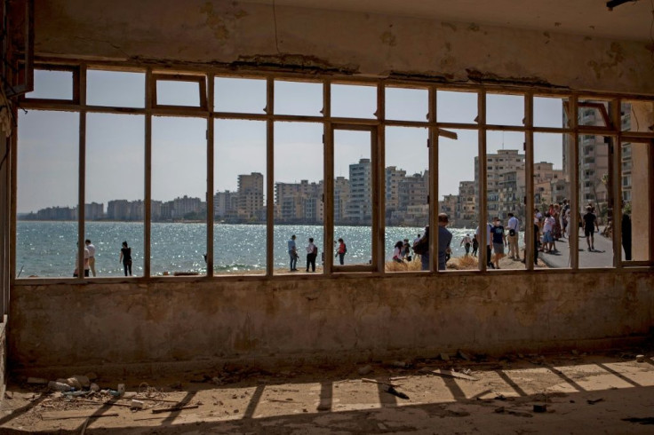 A picture taken from inside an abandoned building shows people visiting Varosha, in the fenced off area of Famagusta, in the Turkish-occupied north of the divided eastern Mediterranean island of Cyprus