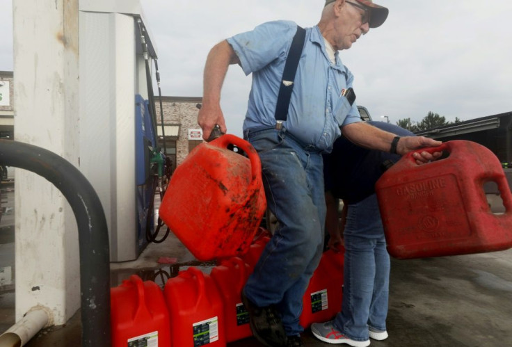 A man returns unfilled cans back to a truck after finding there was no gasoline left at a station in Lacassine, Louisiana as people prepare for Hurricane Delta on October 8, 2020