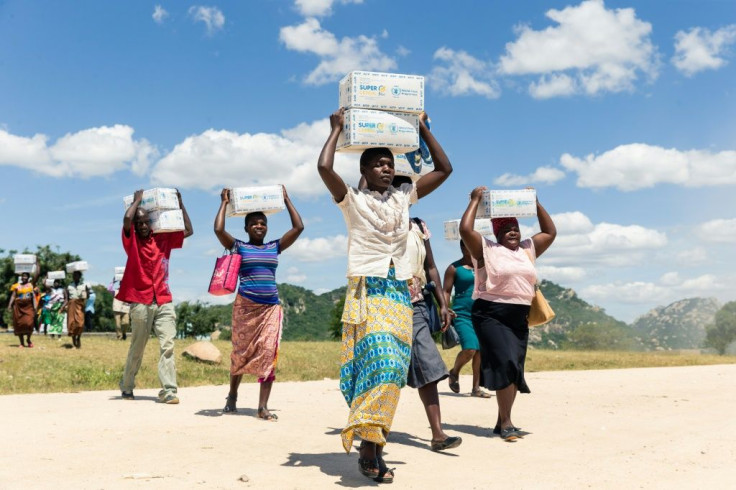 Women carry porridge from the WFP in the drought-hit Mutoko region of Zimbabwe.