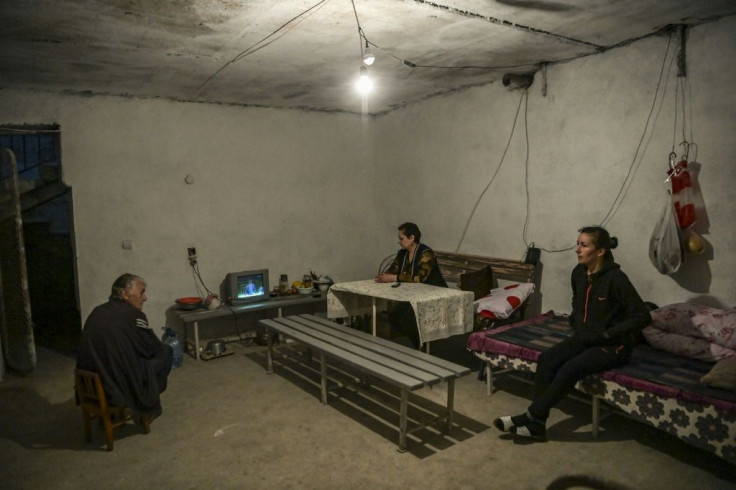 As the battle comes ever closer a family hunkers down to watch television in their basement in Martuni