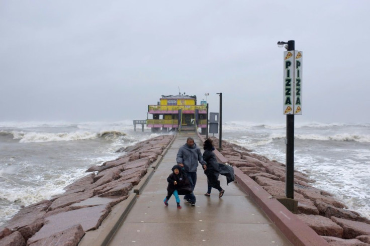 Spectators look out towards the Gulf of Mexico as the outer bands of Hurricane Delta reach Galveston, Texas on October 9, 2020