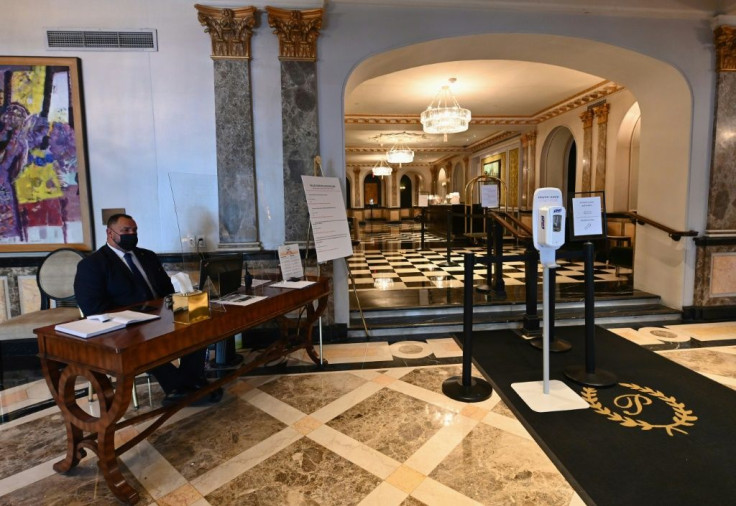 A security officer sits in the lobby of The Pierre hotel, a shadow of its former self amid the coronavirus pandemic