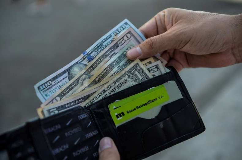 A man shows his wallet with US dollars on a street in Havana, Cuba, in September 2020