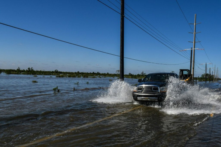 A truck drives through floodwaters in Lake Charles, Louisiana on October 10, 2020 following Hurricane Delta