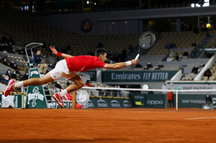 On the stretch: Novak Djokovic returns the ball to Stefanos Tsitsipas in their semi-final