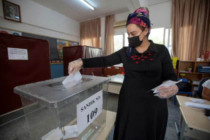 A Turkish-Cypriot woman casts her ballot at a voting station in the northern part of Nicosia, the capital of the self-proclaimed Turkish Republic of Northern Cyprus