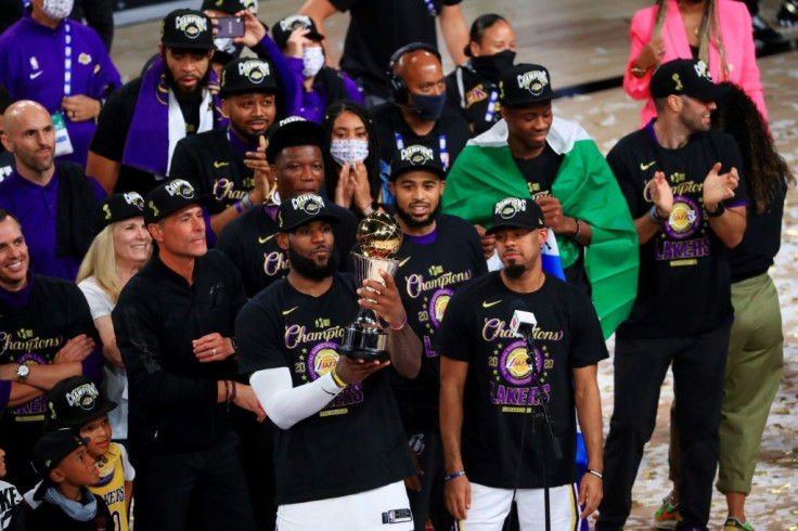 LeBron James celebrates with the NBA championship trophy surrounded by his teammates after the Los Angeles Lakers beat Miami 106-93 Sunday to capture the NBA Finals four games to two