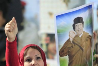 A woman holds a picture of Libyan leader Muammar Gaddafi as she chants slogans during a pro-government rally at the heavily fortified Bab al-Aziziya compound in Tripoli