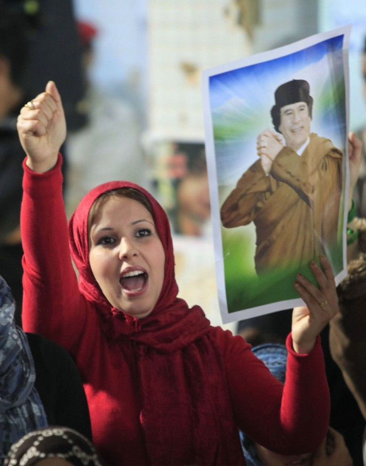 A woman holds a picture of Libyan leader Muammar Gaddafi as she chants slogans during a pro-government rally at the heavily fortified Bab al-Aziziya compound in Tripoli