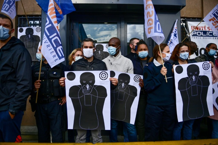 French police officers wearing face masks hold training targets as they gather in front of the police station of Champigny-sur-Marne, outside Paris, on October 12, 2020, to protest against their working conditions.Around 40 people staged an hour-long fire