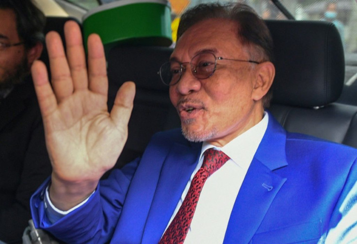 Malaysian opposition leader Anwar Ibrahim waves after meeting the king. Anwar has sought to become prime mnister for more than two decades