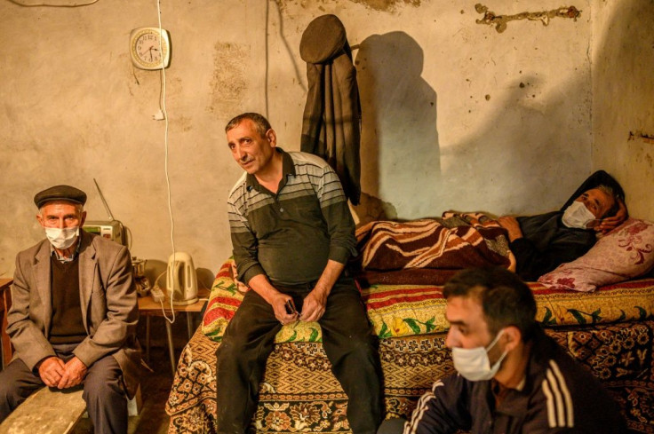 Men shelter from shelling in a basement of a building in Terter