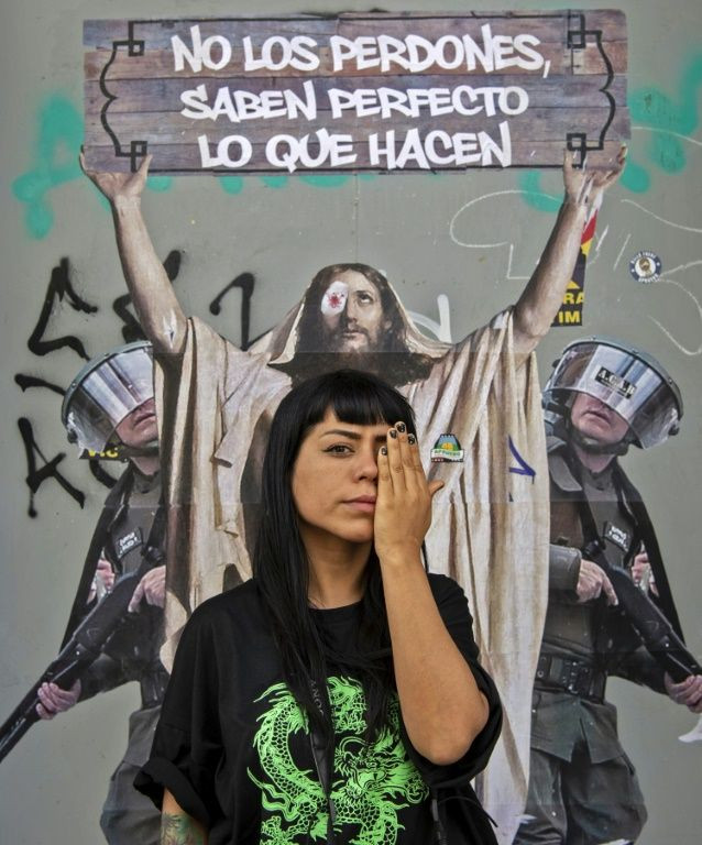Nicole Kramm, 30, poses in front of a protest mural for the victims of security force violence during the social protests that began last year
