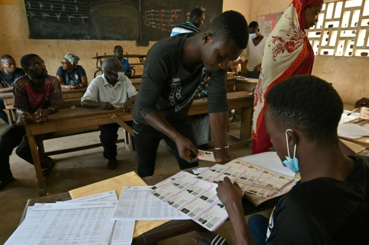 An election official distributes voting cards in Abidjan