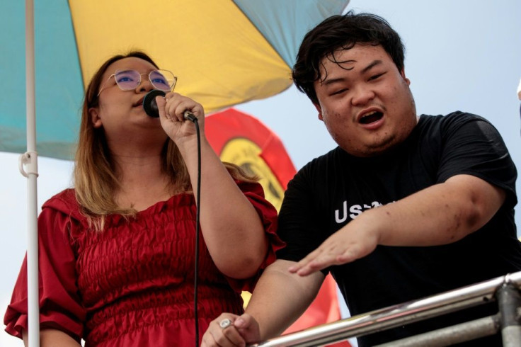 Rung (L) speaks beside pro-democracy activist Parit 'Penguin' Chiwarak at an anti-government rally on Wednesday