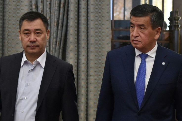 Kyrgyzstan's recently-appointed Prime Minister Sadyr Japarov (L) and former President Sooronbay Jeenbekov (R) walk into the Kyrgyz Parliament extraordinary meeting at Ala-Archa state residence in Bishkek on Friday