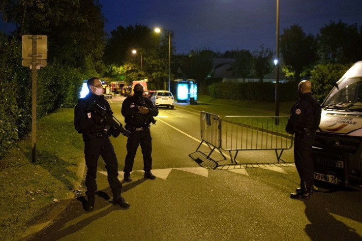 French police officers guard the street in Eragny on October 16, 2020, where an attacker was shot dead by policemen after he decapitated a man