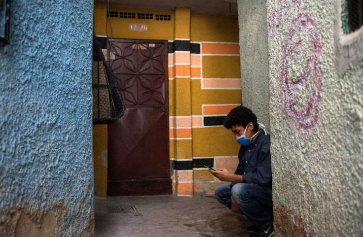 Jonathan Figueroa, 14, looking for a neighbor's wifi signal in Caracas' Bello Campo district, October 2020