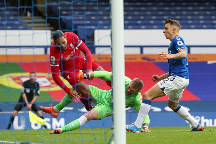 Virgil van Dijk (left)was forced off injured by a late challenge from Jordan Pickford (centre)