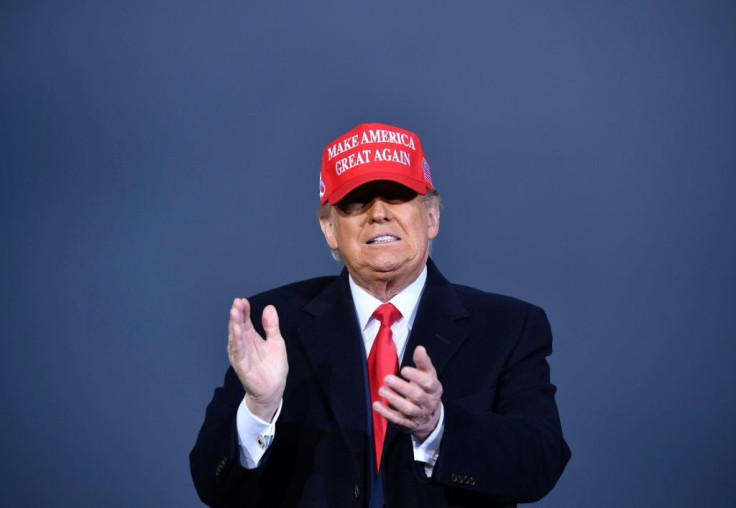 US President Donald Trump claps during a rally at Muskegon County Airport in Muskegon, Michigan on October 17, 2020