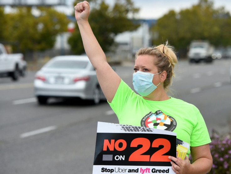 Rideshare driver Erica Mighetto shouts to motorists while urging a "No" vote on Proposition 22 in Oakland, California on October 09, 2020