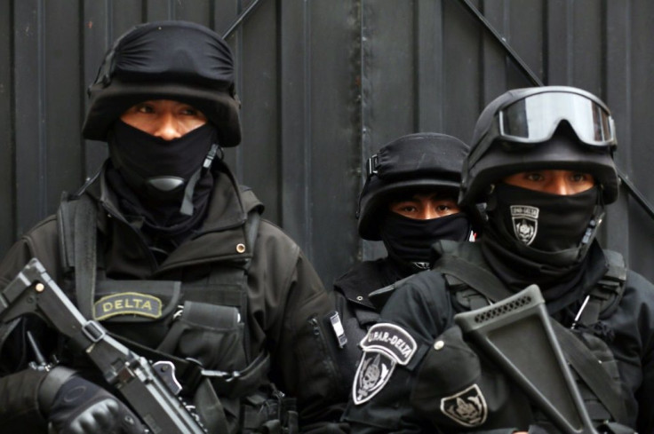 Security forces stand guard as employees of the Electoral Court load a truck with electoral material to be distributed for Sunday's general election in Bolivia