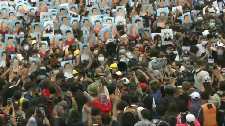 Thai pro-democracy protesters hold up portraits of arrested activists at Bangkok's Victory Monument in the fourth consecutive day of demonstrations in defiance of an emergency decree banning gatherings.