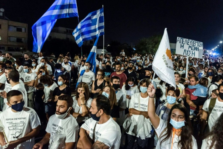 Greek-Cypriots fly flags of Cyprus and Greece during a demonstration at the Deryneia crossing point on the divided island