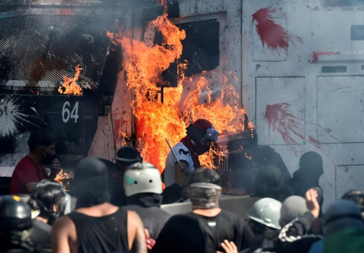 Demonstrators set a police vehicle on fire during clashes between security forces and protesters marking the first anniversdary of Chile's social unrest over inequality