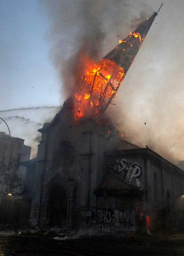 The spire of the Church of the Assumption collapses after severe fire damage