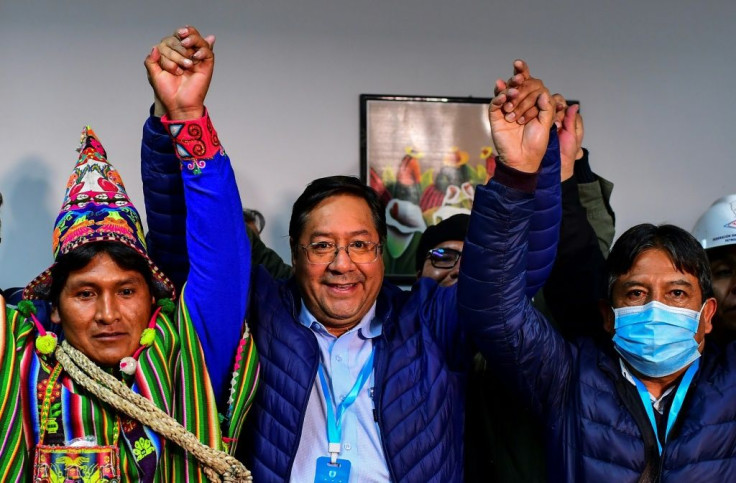 Luis Arce (center) celebrates with running mate David Choquehuanca (right) after exit poll results come in