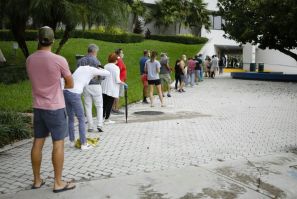 Americans wait in line to cast their ballots in Miami Beach on Florida's first day of early voting, barely two weeks before the tense US presidential election on November 3, 2020