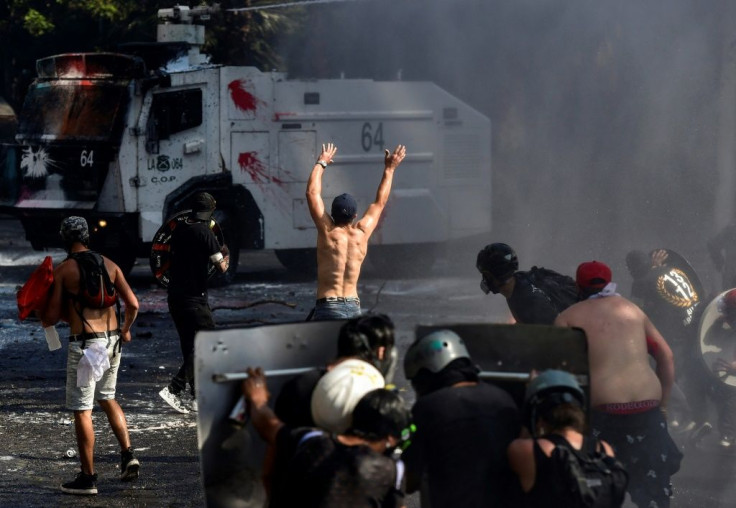 Demonstrators clash with a riot police vehicle as protests marking the October 18 anniversary of the social movement turn violent