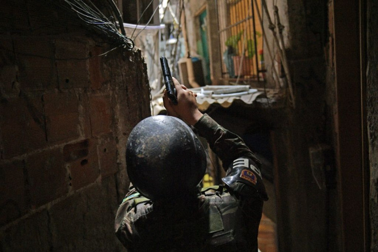 A militarized police officer holds his gun in an alley way at Rocinha favela in Rio de Janeiro, Brazil, on September 25, 2017