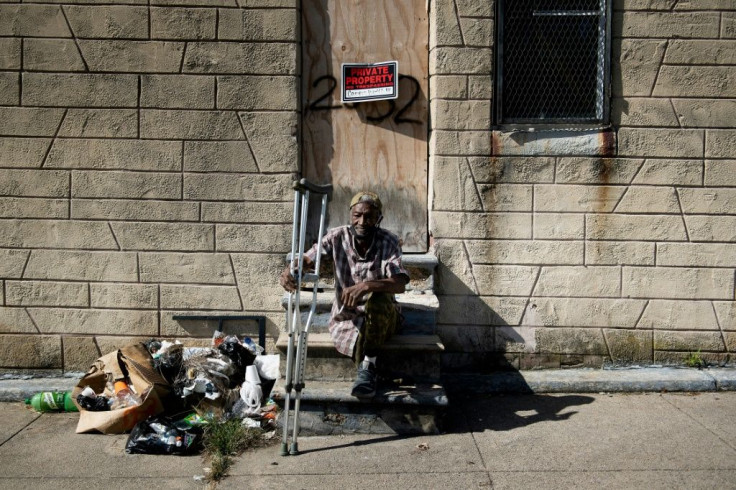 Charles Owens rests in front of an abandoned rowhouse in east Baltimore